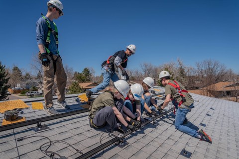 Students on a roof installing solar panels
