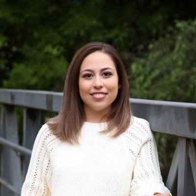 Headshot of Nayeli Aguirre, Graduate Student Employee of the Year. She is wearing a white sweater and has shoulder-length brown hair.