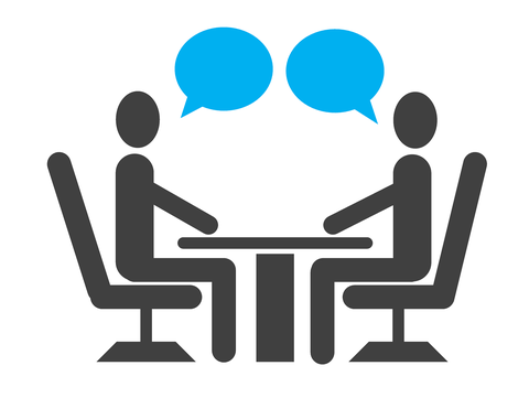 2 cartoon figures sitting across from each other at a table with speech bubbles above their heads